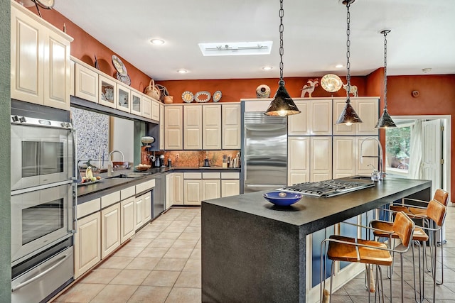 kitchen with dark countertops, light tile patterned floors, stainless steel appliances, and a warming drawer