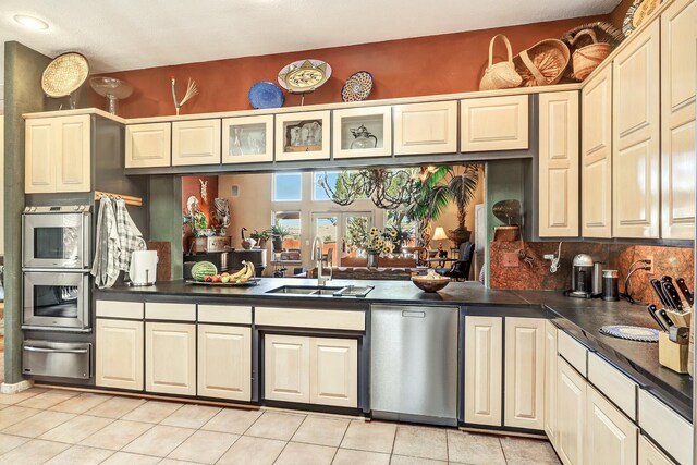 7 Calle Cholla, Placitas, NM 87043 - kitchen with appliances with stainless steel finishes, a warming drawer, dark countertops, light tile patterned floors, and glass insert cabinets