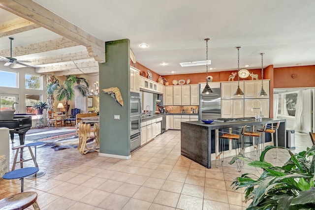 7 Calle Cholla, Placitas, NM 87043 - kitchen featuring appliances with stainless steel finishes, dark countertops, ceiling fan, a kitchen breakfast bar, and decorative light fixtures