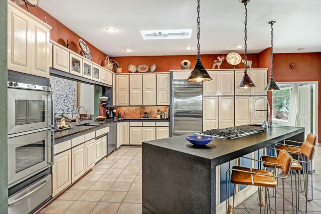 7 Calle Cholla, Placitas, NM 87043 - kitchen with stainless steel appliances, dark countertops, a warming drawer, tasteful backsplash, and light tile patterned floors