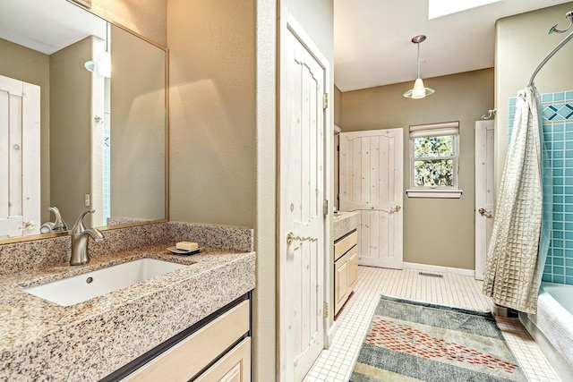 bathroom featuring tile patterned flooring, vanity, and shower / bath combo with shower curtain