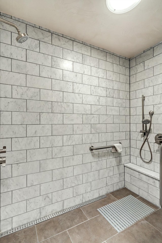 full bathroom with tile patterned flooring and a tile shower