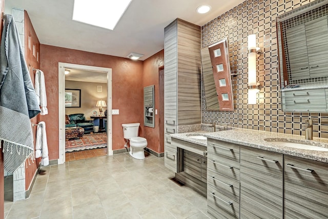 bathroom featuring tasteful backsplash, tile patterned floors, toilet, and baseboards