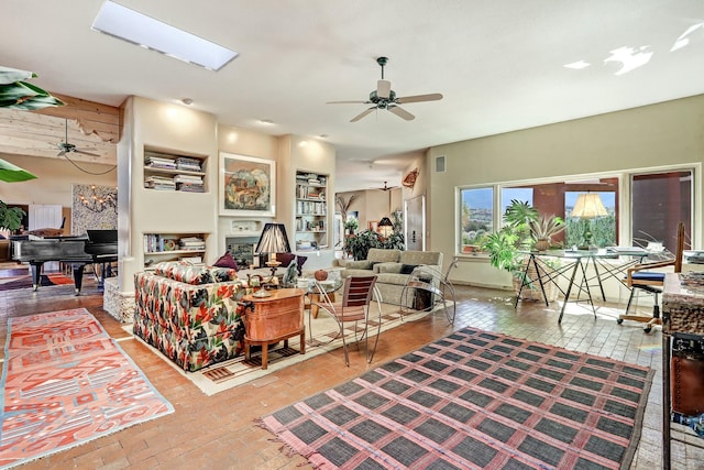 living room featuring a skylight, brick floor, and a ceiling fan