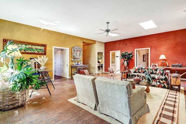 living area featuring brick floor, a skylight, and a ceiling fan