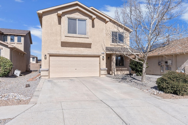 traditional home with a garage, concrete driveway, and stucco siding