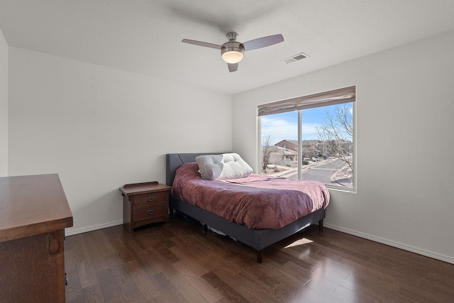 bedroom featuring visible vents, baseboards, and wood finished floors