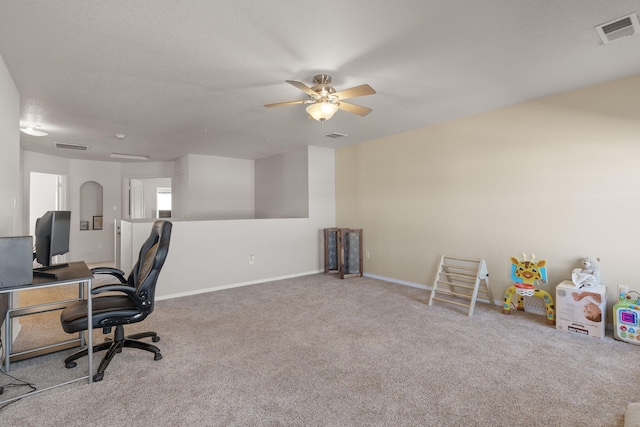 carpeted home office with a textured ceiling, ceiling fan, visible vents, and baseboards