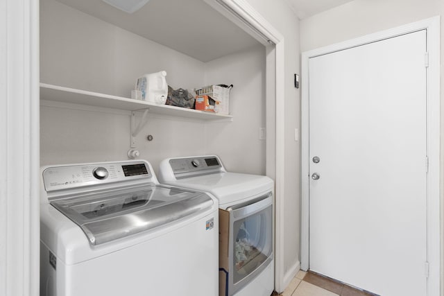 laundry room with laundry area, light tile patterned floors, and washing machine and clothes dryer