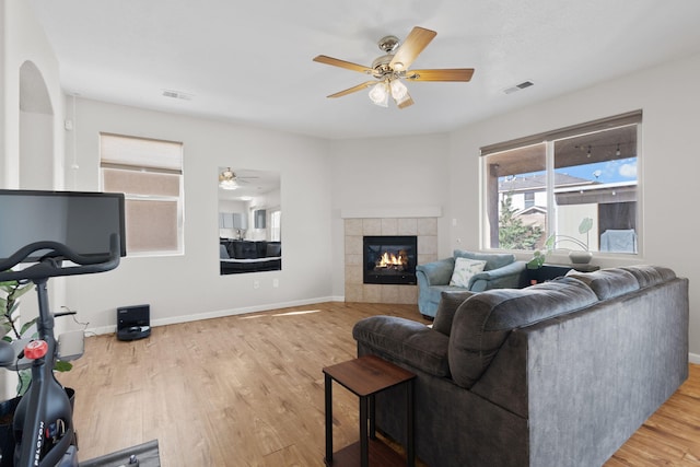 living room with wood finished floors, visible vents, and baseboards