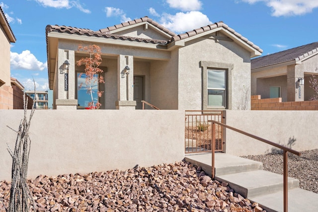 view of front of property featuring a fenced front yard, a gate, and stucco siding