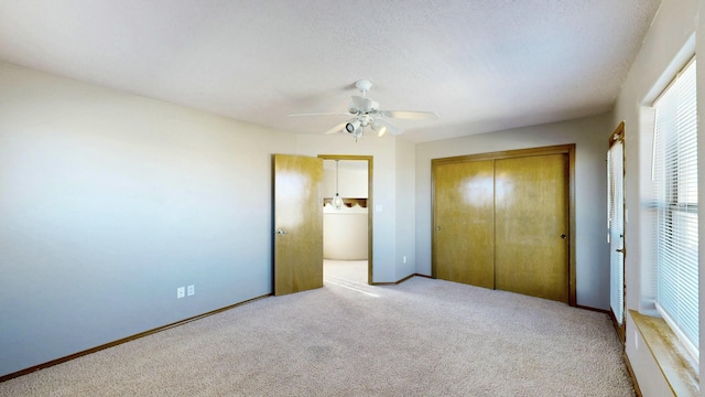 unfurnished bedroom featuring a closet, a ceiling fan, carpet flooring, washer / dryer, and baseboards