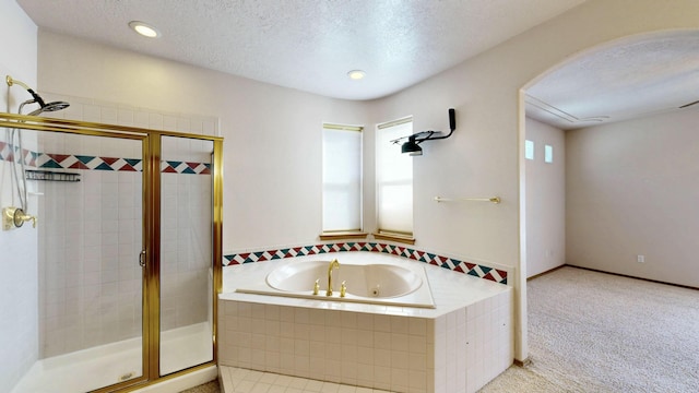 full bathroom featuring a whirlpool tub, a stall shower, a textured ceiling, and recessed lighting