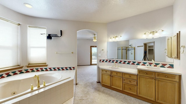 bathroom featuring double vanity, a jetted tub, a sink, and decorative backsplash