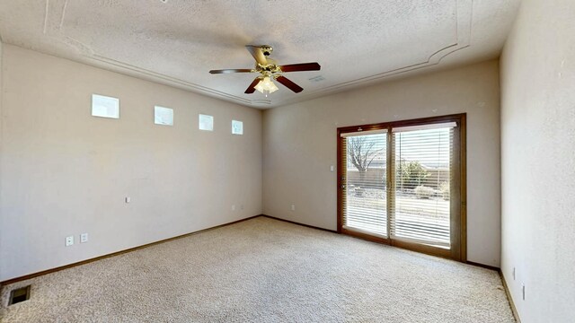 spare room with ceiling fan, a textured ceiling, carpet, and baseboards