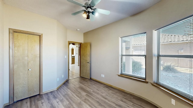 unfurnished bedroom featuring baseboards, a ceiling fan, and light wood-style floors