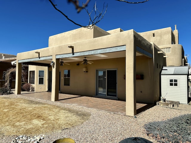 rear view of property featuring a patio area, a ceiling fan, and stucco siding