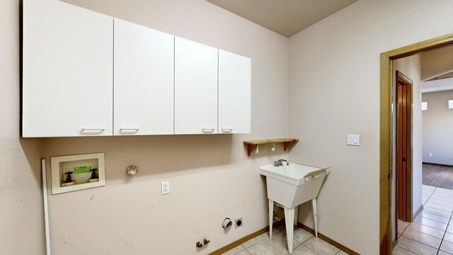 laundry area with light tile patterned floors, cabinet space, baseboards, gas dryer hookup, and hookup for a washing machine