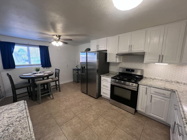 kitchen with tasteful backsplash, white cabinets, a ceiling fan, appliances with stainless steel finishes, and under cabinet range hood