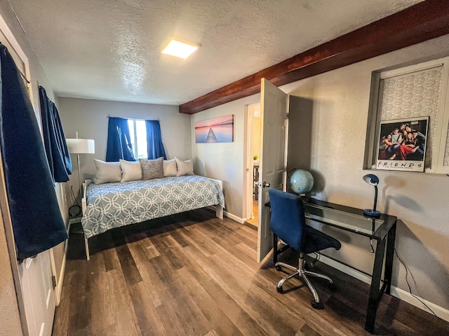 bedroom with beamed ceiling, a textured ceiling, baseboards, and wood finished floors