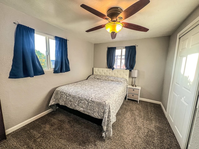 carpeted bedroom with a textured wall, a textured ceiling, baseboards, and ceiling fan