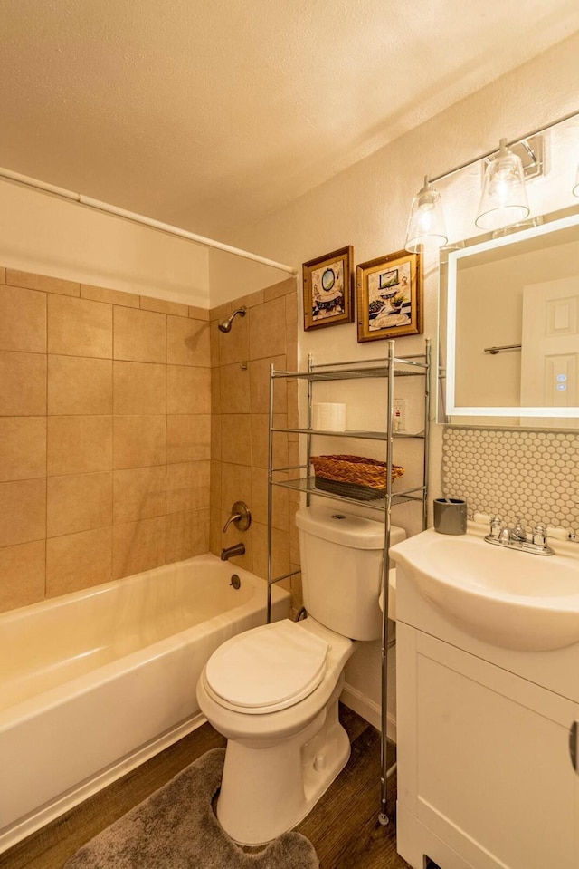 full bathroom featuring decorative backsplash, toilet, wood finished floors,  shower combination, and vanity