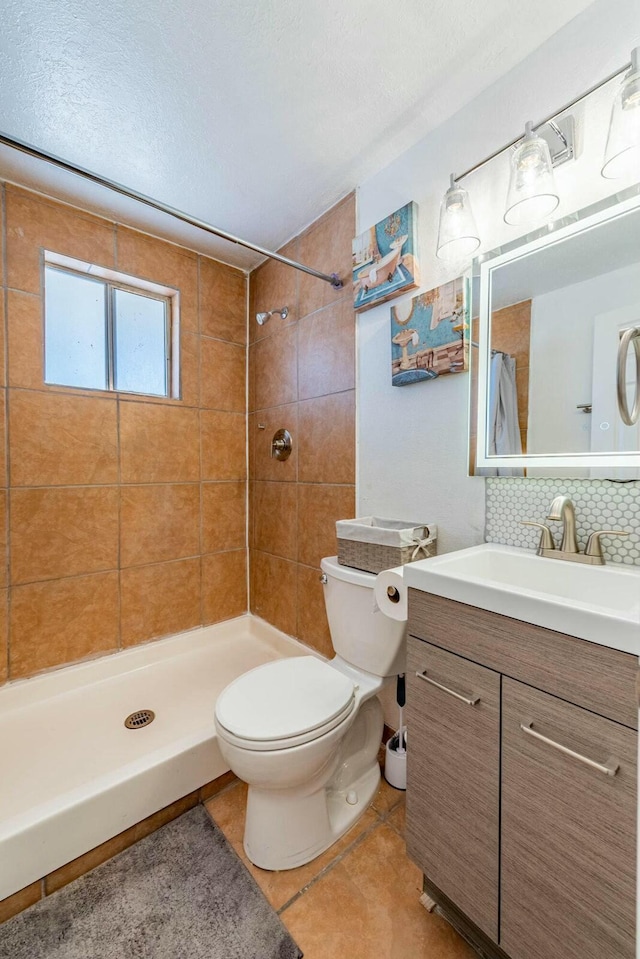 bathroom featuring tiled shower, toilet, a textured ceiling, vanity, and backsplash