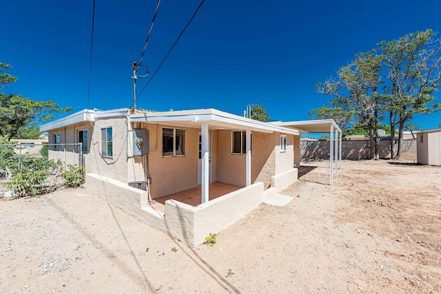 manufactured / mobile home featuring driveway, fence private yard, a patio area, a carport, and stucco siding