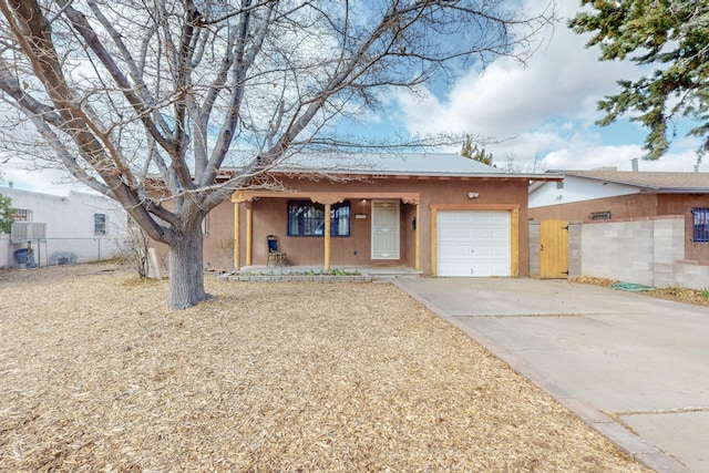 view of front of house with driveway, an attached garage, fence, and stucco siding