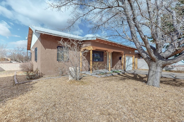 southwest-style home with metal roof and stucco siding