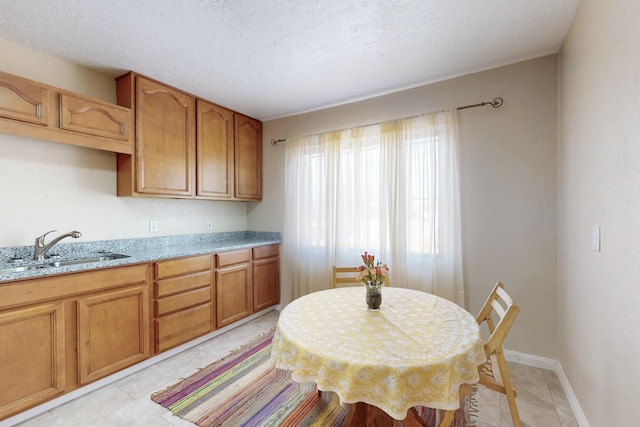 dining room with light tile patterned floors, baseboards, and a textured ceiling