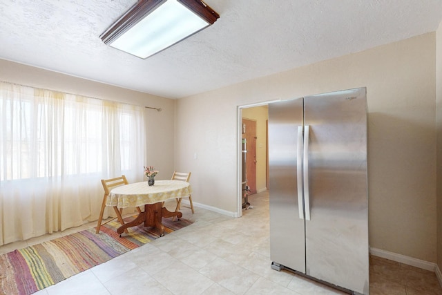 dining room with a textured ceiling and baseboards