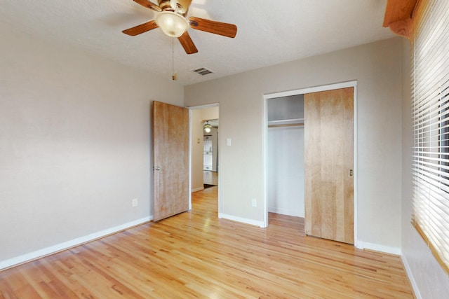 unfurnished bedroom with light wood-style floors, a closet, visible vents, and baseboards