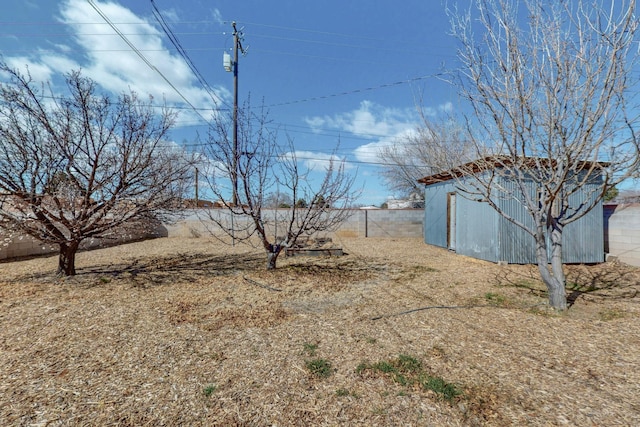 view of yard with a storage shed, fence, and an outdoor structure