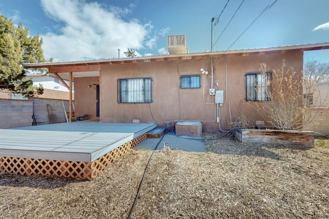 back of house featuring a deck and stucco siding