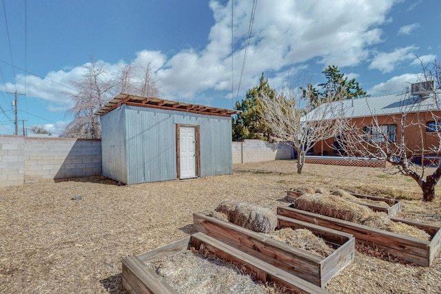 view of shed featuring a fenced backyard and a vegetable garden