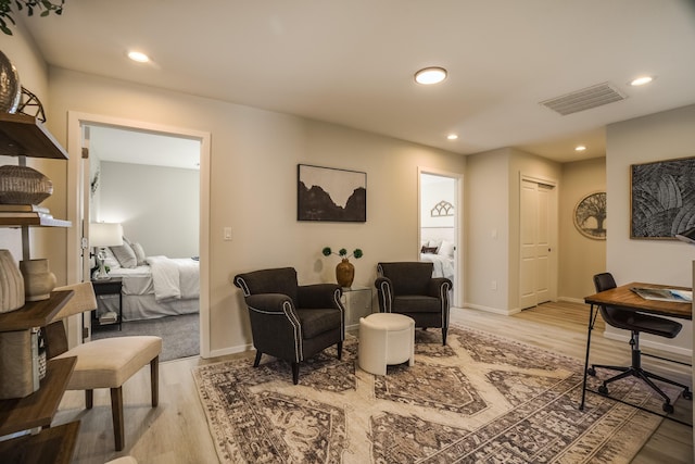 living area with light wood-style floors, recessed lighting, visible vents, and baseboards