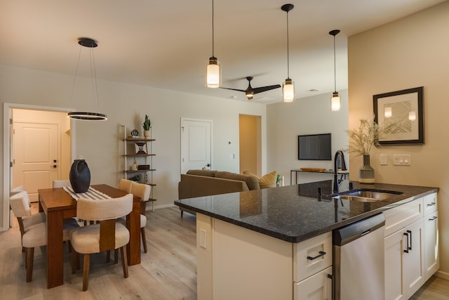 kitchen with a sink, light wood-type flooring, white cabinetry, and dishwasher