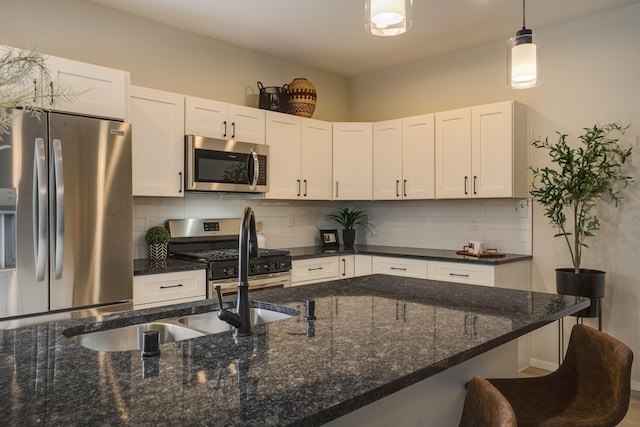 kitchen featuring white cabinetry, appliances with stainless steel finishes, decorative backsplash, and decorative light fixtures