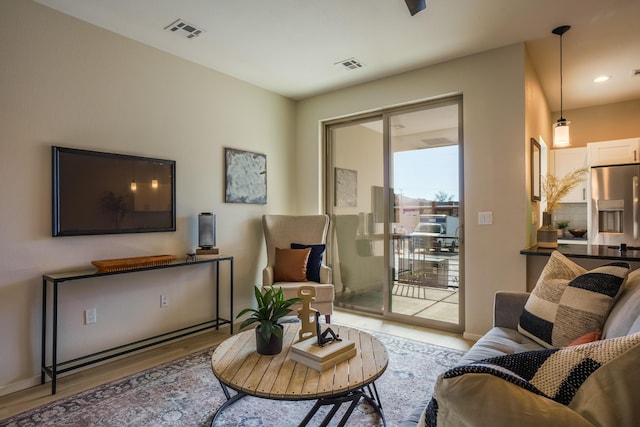 living area with visible vents, baseboards, and wood finished floors