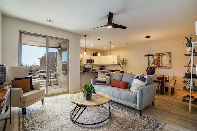 living room with light wood finished floors, recessed lighting, visible vents, ceiling fan, and baseboards