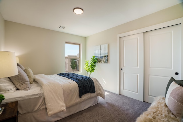 carpeted bedroom featuring a closet and visible vents