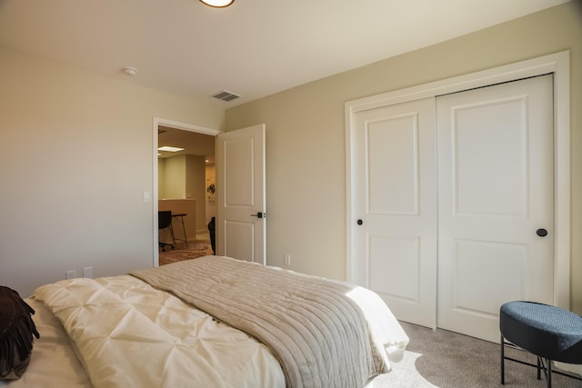 carpeted bedroom featuring a closet and visible vents