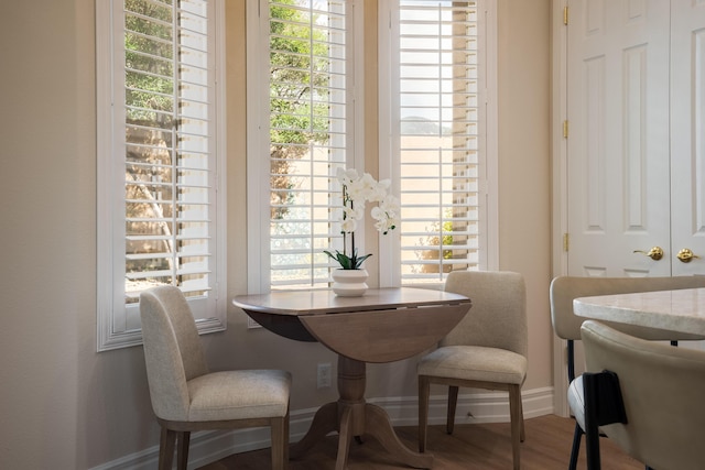 dining area with baseboards and wood finished floors