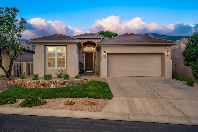 view of front of home with a tiled roof, stucco siding, an attached garage, and concrete driveway