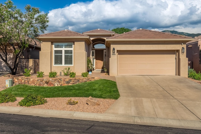 view of front of home with stucco siding, concrete driveway, an attached garage, and a tile roof