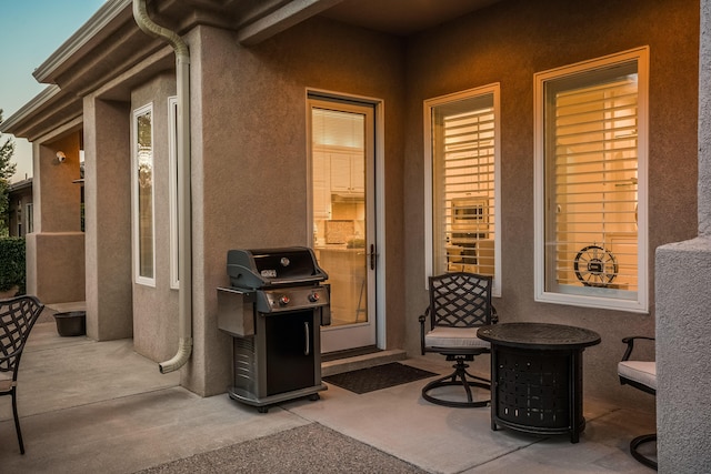 property entrance with stucco siding and a patio area