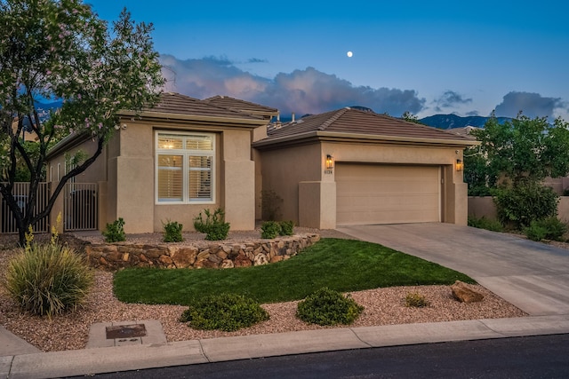 view of front of house featuring stucco siding, a tile roof, fence, concrete driveway, and a garage