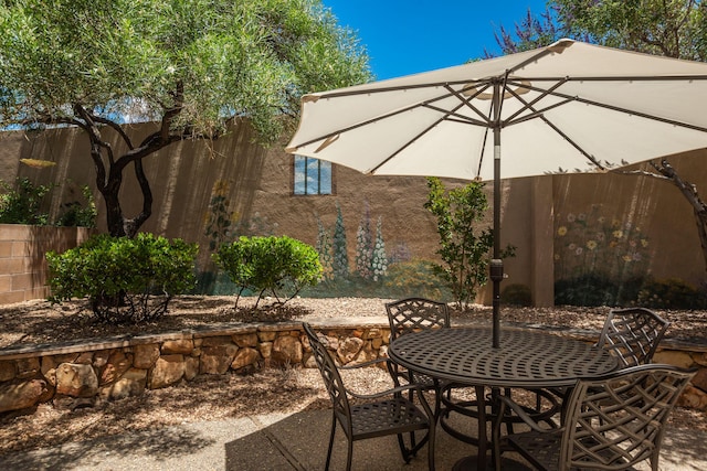 view of patio with outdoor dining space and fence