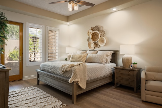 bedroom featuring a ceiling fan, wood finished floors, baseboards, a textured ceiling, and access to outside